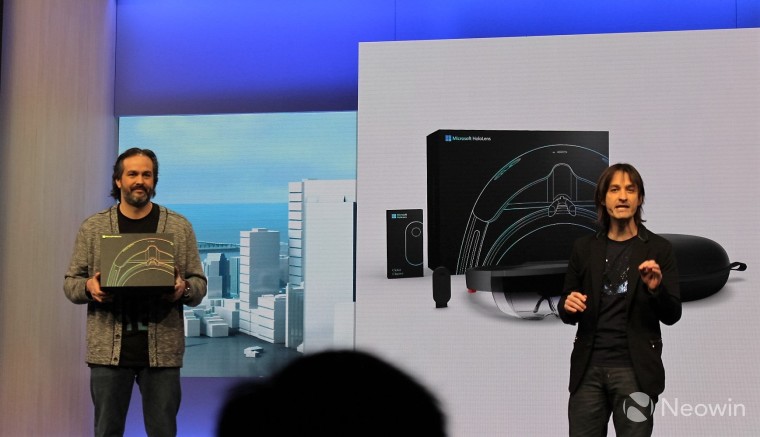 Alex Kipman on the right of the HoloLens conference stage with a person on the left