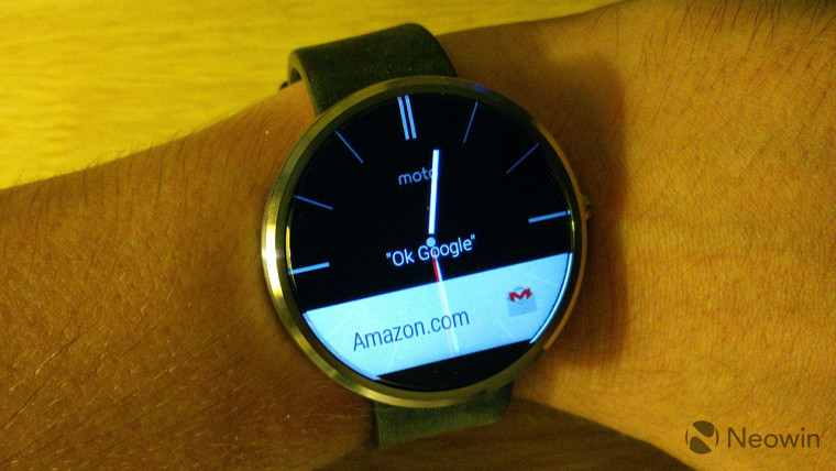First-gen Moto 360 on arm with wooden background