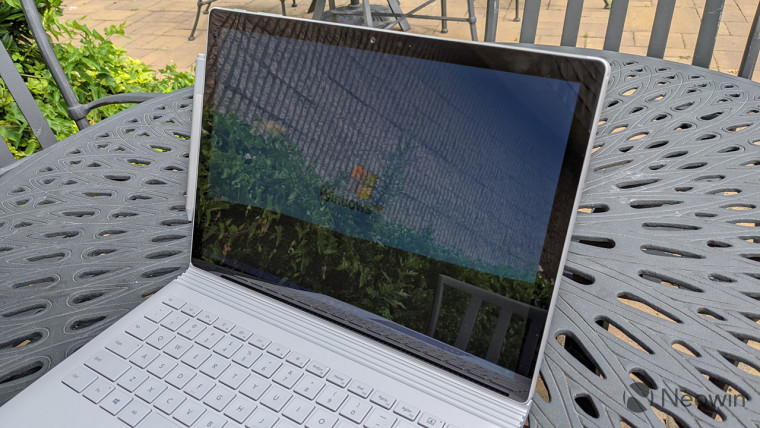 Surface Book 3 on a table with a Surface Pen attached on the left