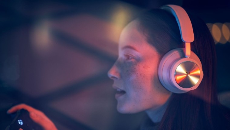 Woman wearing a Beoplay Portal headset while playing with an Xbox controller