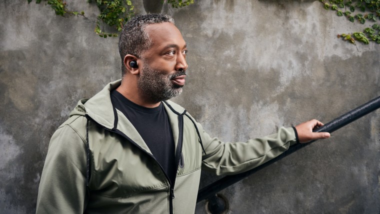 A man wearing Amazon&039s all-new Echo Buds in his ear