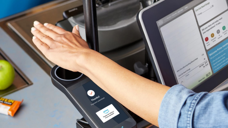 An Amazon customer is using the contactless payment service Amazon One which scans the palm