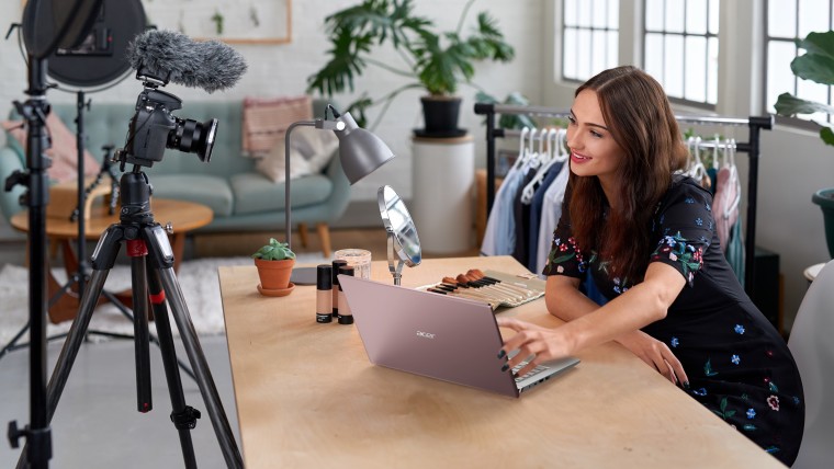 A woman using the Acer Swift X on a desk with recording equipment pointed at the desk