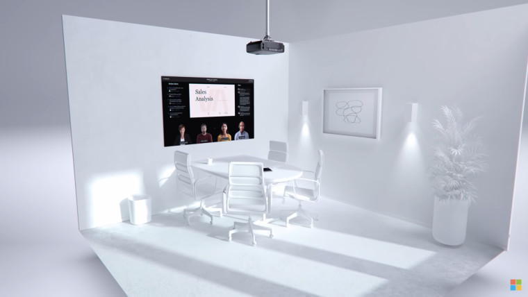 A white room with a table and chairs with a large display showing a Teams call