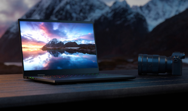 The Razer Blade 15 on a bench with a mountain on the background